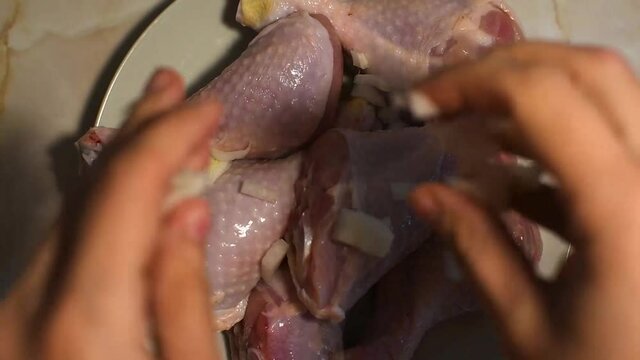 cooking chicken legs. Raw chicken legs are sprinkled with chopped onions