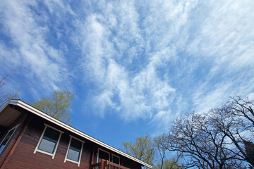Blue sky and white clouds over the wooden house
