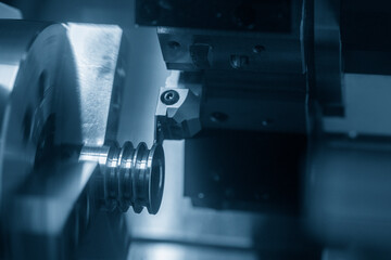 The  CNC lathe machine groove cutting the pulley parts. The hi-technology metal working processing by CNC turning machine .