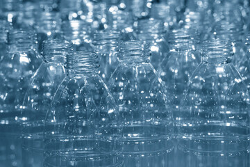 The PET bottles  on the conveyor belt for filling process in the drinking water factory. The hi-technology of plastic bottle manufacturing process.