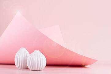 Bright spring fresh pink interior with white ceramic vases in sunlight with flares, hovering bend paper, glowing peak. Elegant geometric background.
