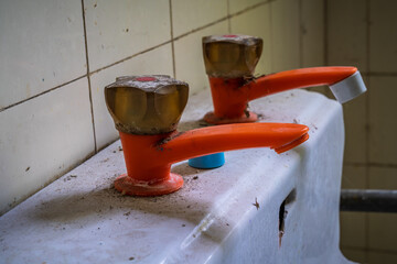Closeup of an old pastic water tap in a derelict house