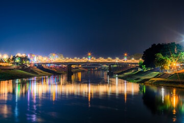 Fototapeta na wymiar Beautiful light on the Nan River at night on the bridge (Naresuan Bridge) on the Road in Realm for Naresuan the Great Festival and Annual event in Phitsanulok,Thailand.