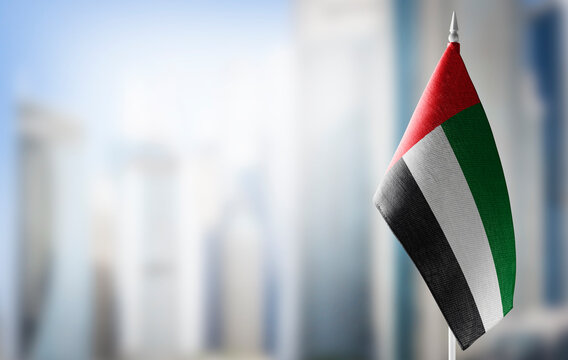 A small flag of United Arab Emirates on the background of a blurred background