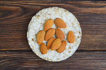 cereal breakfast crisp bread with almond nuts isolated on wooden background, diet, vegetarianism, healthy food
