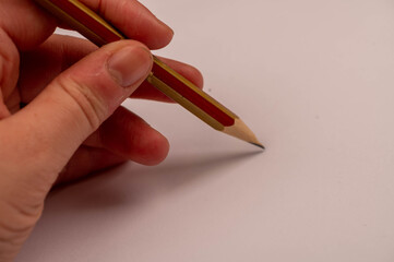 A girl's hand drawing with a pencil on a white sheet of paper. Self-isolation in the covid-19 pandemic.