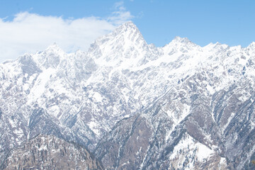 Snowcapped mountains against cloudy sky