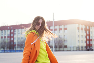 Lifestyle Portrait of cheerful brunette young woman in trendy colorful casual outfit looking over shoulder. Street Style. Good-looking Millennial Hipster Girl having fun sunny outdoors