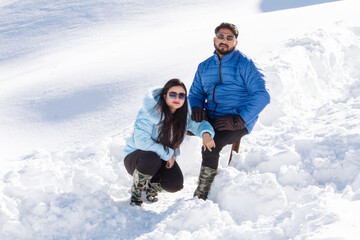 Fototapeta na wymiar Couple in warm clothing spending leisure time on snow during ski holiday