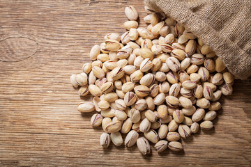 pistachios in a sack on a wooden background
