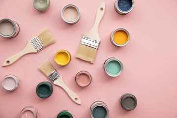 Overhead view of a DIY paint brush with bright sample paint pots