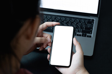 Top view of businesswoman using smartphone on workplcae with blank white screen. mock up mobile phone.