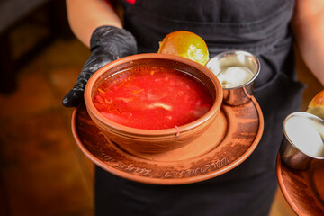 Ukrainian traditional borsch. Russian vegetarian red soup in a bowl served by waiter in restaurant or diner.