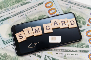 inscription on cubes and sim card and the on smartphone, and dollar banknotes. concept of paying...