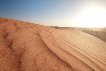 Sunset over the sand dunes in the desert.