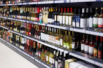 Selbstklebende Fototapeten Regale mit verschiedenen Alkoholsorten zum Verkauf im Supermarkt © Loraliu