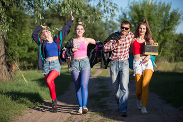 A man with a cassette tape recorder and beautiful girls dressed in the style of the nineties. A village cheerful company goes to a club for a disco.