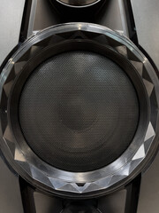 Close-up of musical stereo speaker with protective grill. Modern black audio speaker or music...