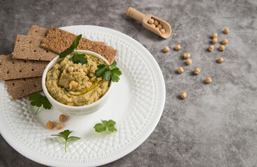 Turkish pea paste chickpea hummus in a plate on a gray background. Copy space