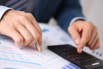 Black calculator and financial statistics on infographics