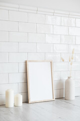 Scandinavian room interior with mockup photo frame, candles, vase of dried flowers. Brick tiles wall on background. Scandinavian, nordic style.