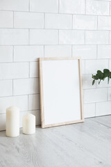 Empty poster frame in cozy interior. Frame mockup. Brick tiles wall on background. Scandinavian, nordic style.