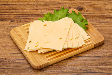 Sliced yellow cheese over board