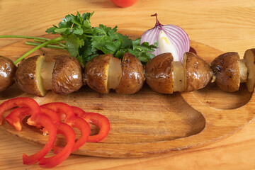 baked potatoes on a wooden plate. Grilled potatoes with fresh vegetables

