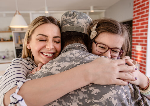 Soldier hugging with his family at home.