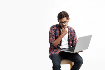 Young indian man thinking some idea when working on laptop.