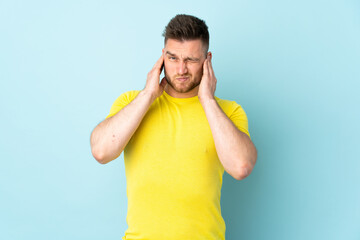 Russian handsome man isolated on blue background frustrated and covering ears