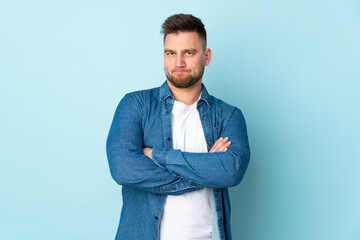 Russian handsome man isolated on blue background feeling upset