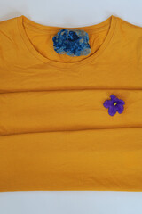 Yellow plain shirtsleeve cotton T-Shirt mockup on gray background  with    blue flower and paint stone