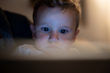 Authentic close up shot of toddler baby boy while using technology tablet kept by mother for family entertainment  before asleep. Concept of technology, new generation,family, connection,parenthood