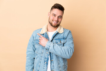 Russian handsome man over isolated background pointing to the side to present a product