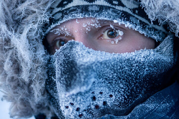 Portrait of a man in winter clothes and a mask. A traveler in the Arctic. Ice and snow on...