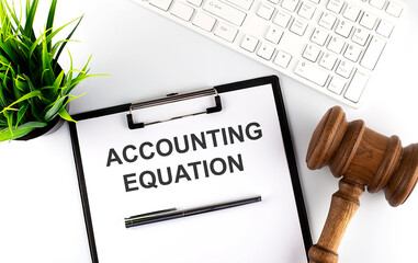 White office desk table with blank sheet with text ACCOUNTING EQUATION , keyboard and gavel, top...