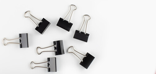 black binder clip on white background. Close up view. Copy space