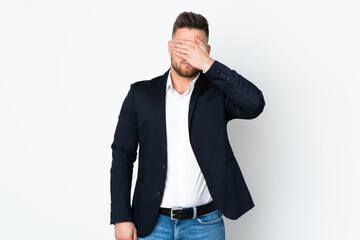 Fototapeta premium Young Russian business man isolated on white background covering eyes by hands