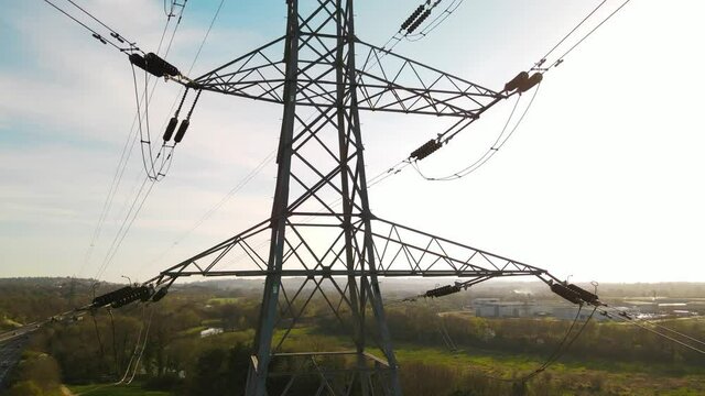Electricity pylons aerial shot from a drone. Moving along two row of pylons. electric high voltage pylon against beautiful sky. energy efficiency conception.