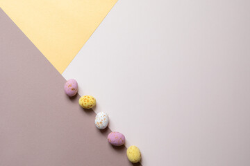 Easter composition. Easter eggs, paper blank on pastel background. Flat lay, top view, copy space.