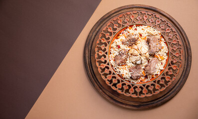 The concept of oriental cuisine. Traditional asian dish - pilaf from rice, vegetables and meat in a plate on a paper background. background image. top view, copy space, flat lay
