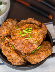 Buckwheat cutlets with meat in cast iron, served with sour cream. Healthy food