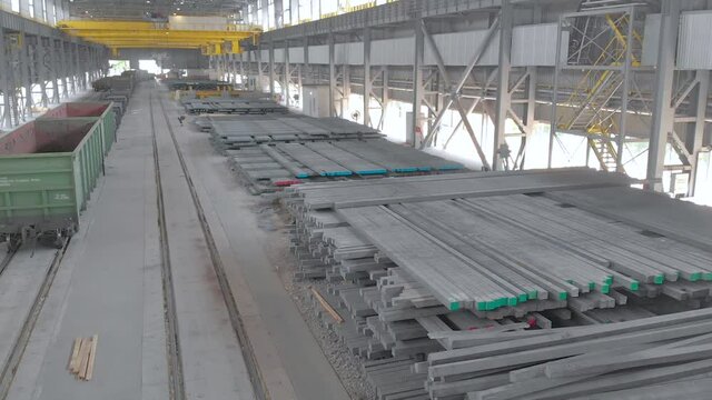 The work of an overhead crane at a factory. Working process at a metal production factory. Crane work at the factory. Yellow overhead crane in a modern factory
