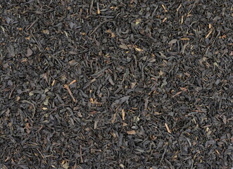 Fototapeta premium Dry black tea leaves background. Ful frame black tea background. Black tea texture surface.