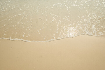 Fototapeta na wymiar Soft ocean wave on tropical sandy beach in summer background