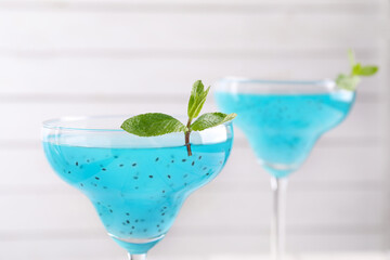 Delicious cocktail with basil seeds and mint on white background, closeup