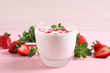 Delicious drink with strawberries on pink table