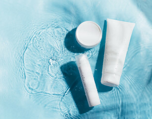 Cosmetics foam gel shampoo bright blue background water with foam bubbles. Cosmetics products for...