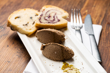 Fresh homemade liver pate on bread over rustic background